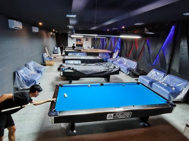 seorang pemain Billiard tengah berjuang untuk memasukkan bola sasarannya